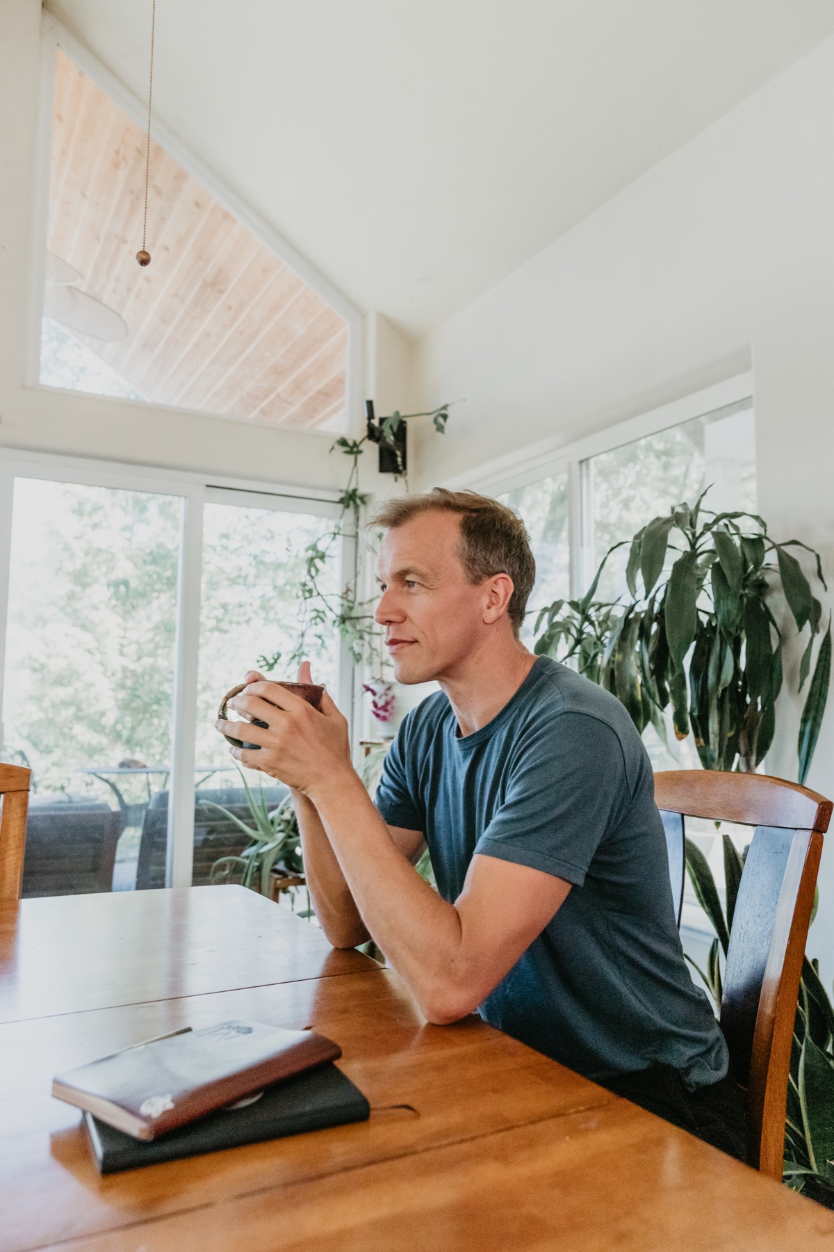 Nick Tong holding a coffee, warm morning window light